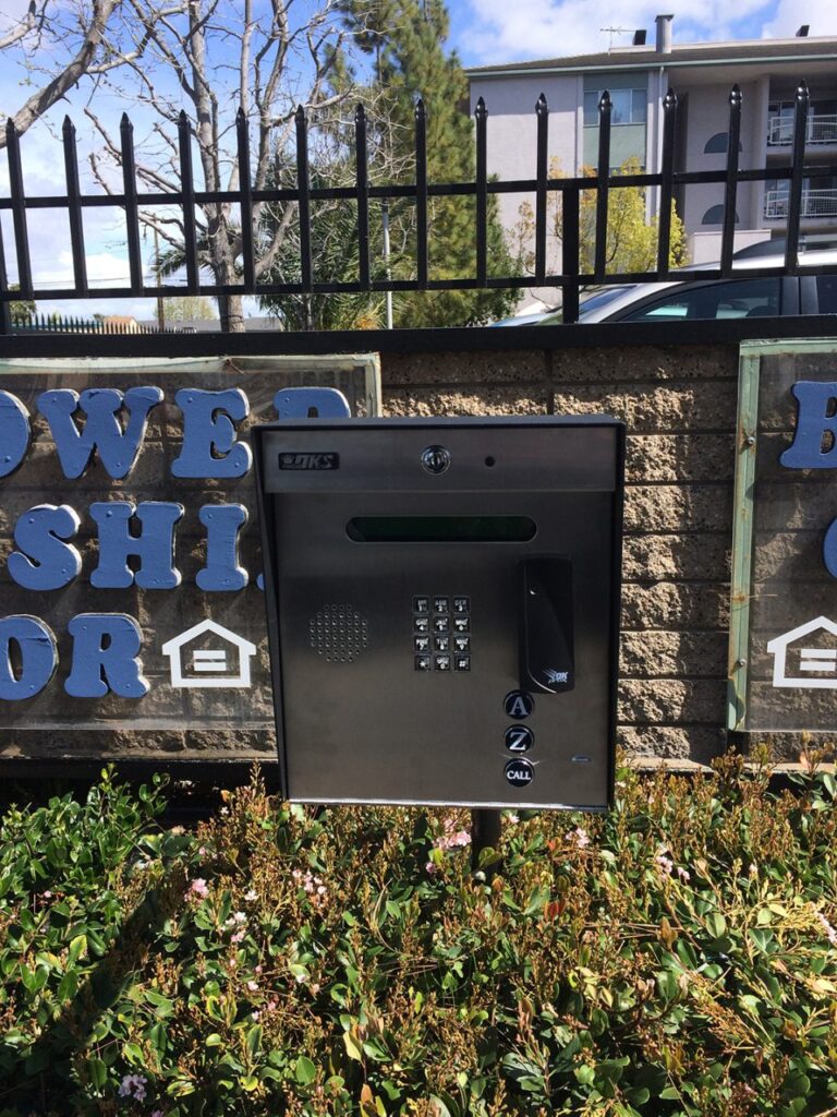 Access control keypad and intercom panel mounted at a gated property entrance