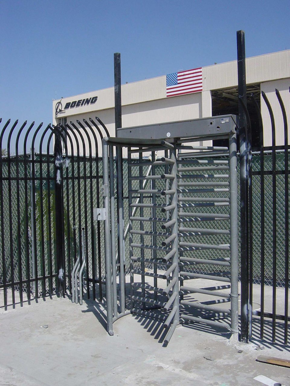 Full-height security turnstile and perimeter fencing at an aerospace manufacturing facility