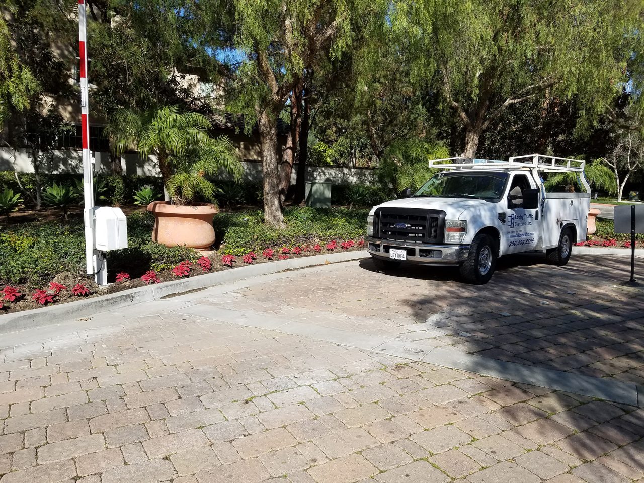 Barrier arm gate controlling vehicle entry with a Lobby Traffic Systems service truck onsite