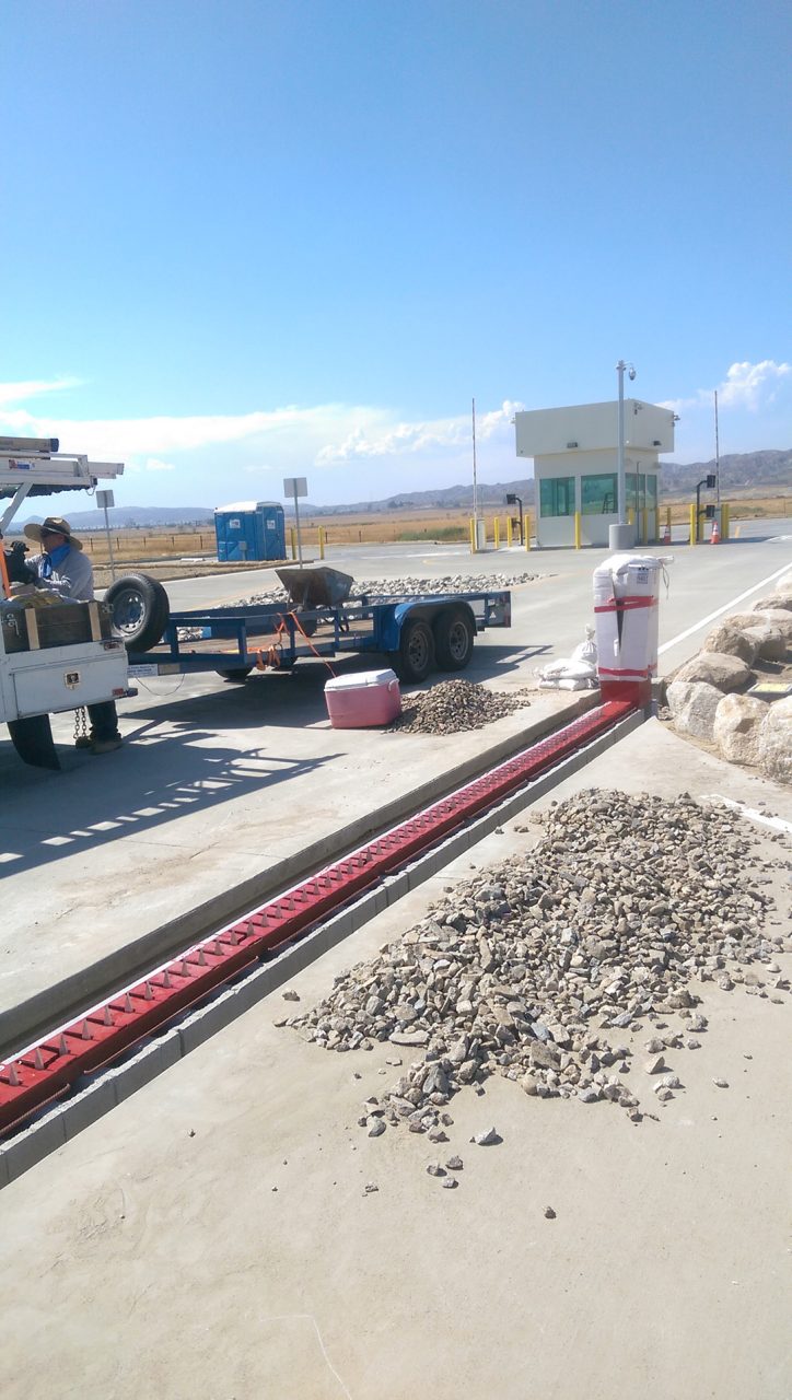 Guard booth and traffic spikes controlling a secured vehicle checkpoint